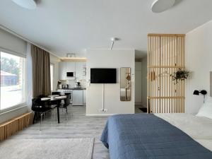 a bedroom with a bed and a kitchen with a desk at Cozy City Apartment with Parking space and WiFi in Vaasa