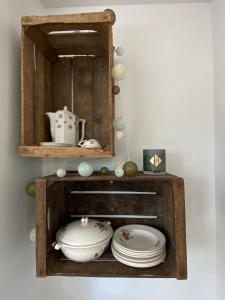 una estantería de madera con platos y platos. en Chalet bain nordique - Calm & relax, en Bellême