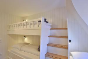 a bedroom with a bunk bed and a staircase at Strandvilla Marina 28 - Traumblick in Wangerooge