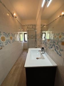 a bathroom with a white sink and a shower at PortaLecce B&B in Brindisi