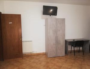 a room with a desk and a television on a wall at CON MARIO e ALMERINA in Frascaro