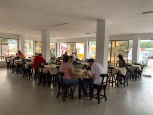 a group of people sitting at tables in a restaurant at La SOSTA in Yumbo