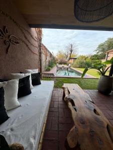 a room with a bed and a table and a pool at Tanah Host - Casa de Huespedes in Villa Mercedes