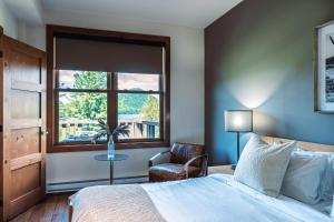 a bedroom with a bed and a window and a chair at Lakefront Mountain View Remote Work - 1 Bd Suite in Lac-Superieur
