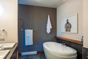 a bathroom with a white tub and a sink at Lakefront Mountain View Remote Work - 1 Bd Suite in Lac-Superieur +43 photos