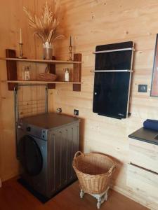 una lavanderia con lavatrice e cesto di Le Chalet de la Femme du Pêcheur a Peigny Altre 71 foto