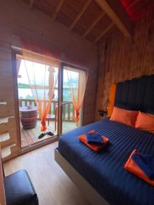 una camera da letto con un letto con lenzuola blu e una grande finestra di Le Chalet de la Femme du Pêcheur a Peigny