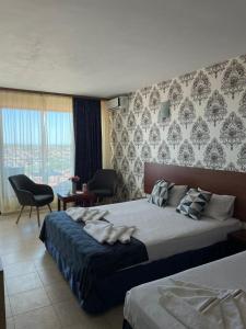 a hotel room with a bed with towels on it at Moreno in Sozopol