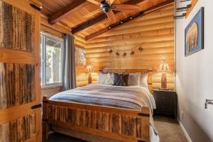 una camera con un letto in una baita di tronchi di Little Lakeview Lodge a Big Bear Lake