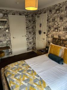 a bedroom with a bed with a patterned wall at The Blackhorse Accommodation in Newton Stewart +31 photos
