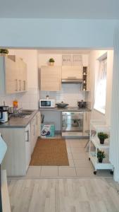 a kitchen with white cabinets and a counter top at Appart confort Paris Cergy gare in Cergy