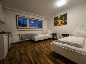 a white room with two beds and a window at Budget Studio - 2 Einzelbetten - Parkplatz in Dornbirn