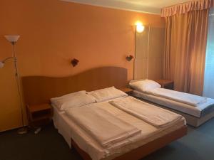 a hotel room with two beds and a lamp at Tifani Szálló in Balatonlelle +21 photos