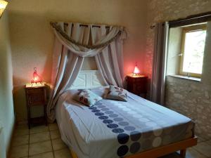 a bedroom with a bed with two lamps and a window at Le Vignal in Monflanquin +119 photos