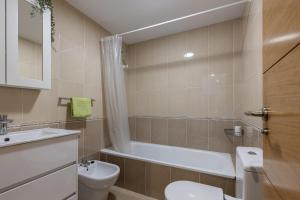 a bathroom with a toilet and a tub and a sink at Piso A Pie de Playa - A Corna in San Pedro +11 photos