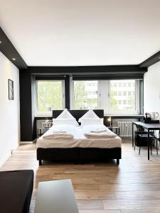 a bedroom with a large bed and a table at BLK Hostel in Düsseldorf