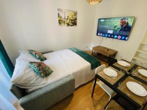 a bedroom with a bed and a desk with a television at Appartement,Paris Nord,Eurostar,Thalys,Sacré-Cœur in Paris