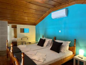 una camera da letto con un letto grande con una parete blu di Symi Central Point a Sými