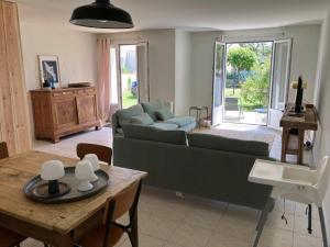 a living room with a couch and a table at Maison Dunes des Huttes in Saint-Denis-dʼOléron +13 photos