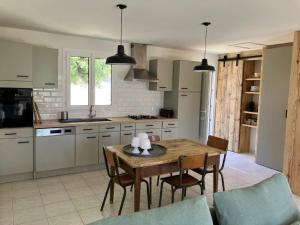 a kitchen with a table and chairs in a kitchen at Maison Dunes des Huttes in Saint-Denis-dʼOléron