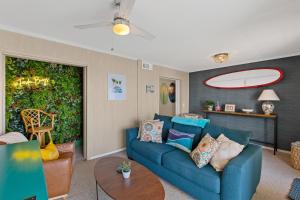 a living room with a blue couch and a table at Tropical Winds - Ferda Buoys in Carolina Beach