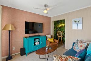 a living room with a blue cabinet and a tv at Tropical Winds - Ferda Buoys in Carolina Beach