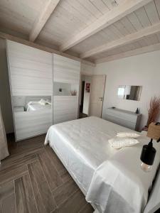 Un dormitorio con una gran cama blanca. en Casa vacanze Iris, en Carbonia