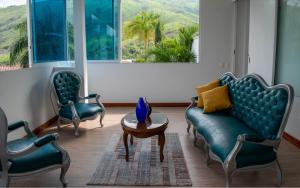 a living room with two chairs and a couch and a table at Tu apartameto ideal para disfrutar Cali in Cali
