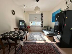 a living room with a table and a couch at Kodikas ja supermukava asunto metron vieressä! Smart TV, nopea netti, 5 minuuttia keskustaan! in Helsinki +4 photos
