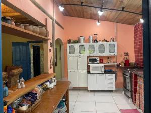 a kitchen with pink walls and white cabinets at Pousada Tiê-Sangue in Iporanga