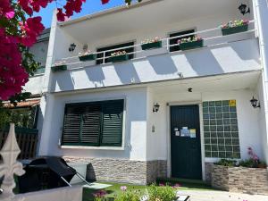 a white house with potted plants on the balcony at Bing Garden Guesthouse in Lisbon +21 photos