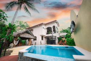 a villa with a swimming pool in front of a house at Villa Cascada By Vacation Pura Vida in Esterillos Este