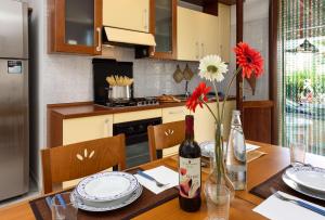 una cucina con tavolo, bottiglia di vino e fiori di Casa Karuscia a San Vito lo Capo