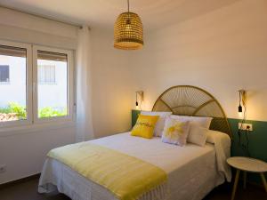 a bedroom with a bed with yellow and white pillows at Apartamento O lago in Valdoviño