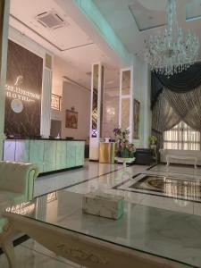una hall con tavolo in vetro e lampadario pendente di Frazel Heritage Hotel a Alor Setar