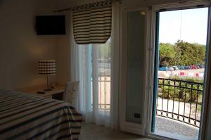 a bedroom with a sliding glass door to a balcony at Agriturismo Dolceacqua in Cavallino-Treporti