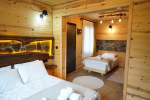 a bedroom with two beds in a log cabin at Perla garden suit in Çamlıhemşin
