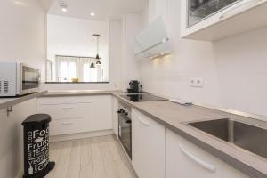 a white kitchen with a sink and a microwave at Livemálaga Alta Suite & Parking in Málaga