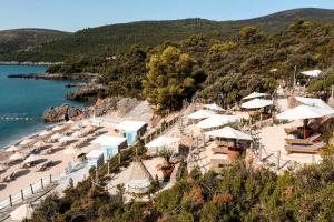 a beach with umbrellas and chairs and the water at LUSTICA BAY GARDEN APARTMENT, Centrale in Tivat