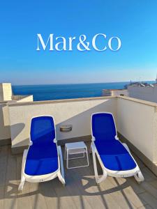 2 blaue und weiße Stühle auf einem Balkon mit Meerblick in der Unterkunft Mar&Co in Polignano a Mare