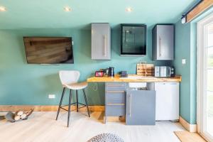 a kitchen with blue walls and a table and chairs at Self contained cabin, firepit, NR MOD aztec, m5, m4 in Bristol