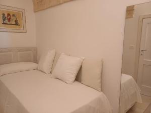 a white bed with white pillows in a room at Casamareluna in Ostuni