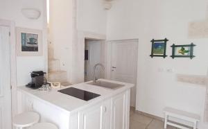 a white kitchen with a sink and a counter at Casamareluna in Ostuni +7 photos