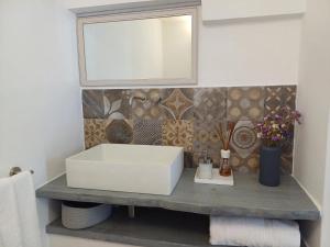 a bathroom with a white sink and a mirror at Casamareluna in Ostuni