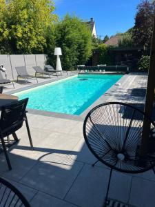 una piscina con sedie, tavolo e sedia di Magnifique Villa Piscine Jacuzzi a Angres