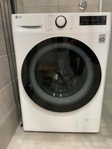 a white washing machine sitting in a room at Lägenhet nära Mariehamn Vedbastu på gården in Kalmsta