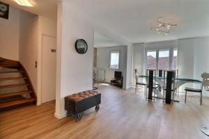 un salon avec une table et une horloge murale dans l'établissement Le Factory - Grand & Lumineux - Mon Groom, à Troyes