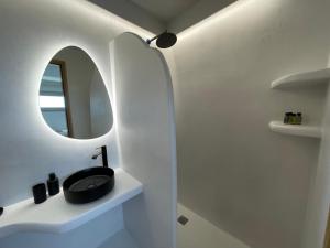 bagno con lavandino nero e specchio di Solo Sole Suites Santorini a Éxo Goniá