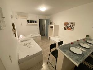 a small white kitchen with a table and a room at Votsalo in Ios Chora