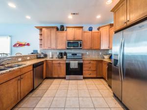 a kitchen with wooden cabinets and a stainless steel refrigerator at Sand By Me in Surf City